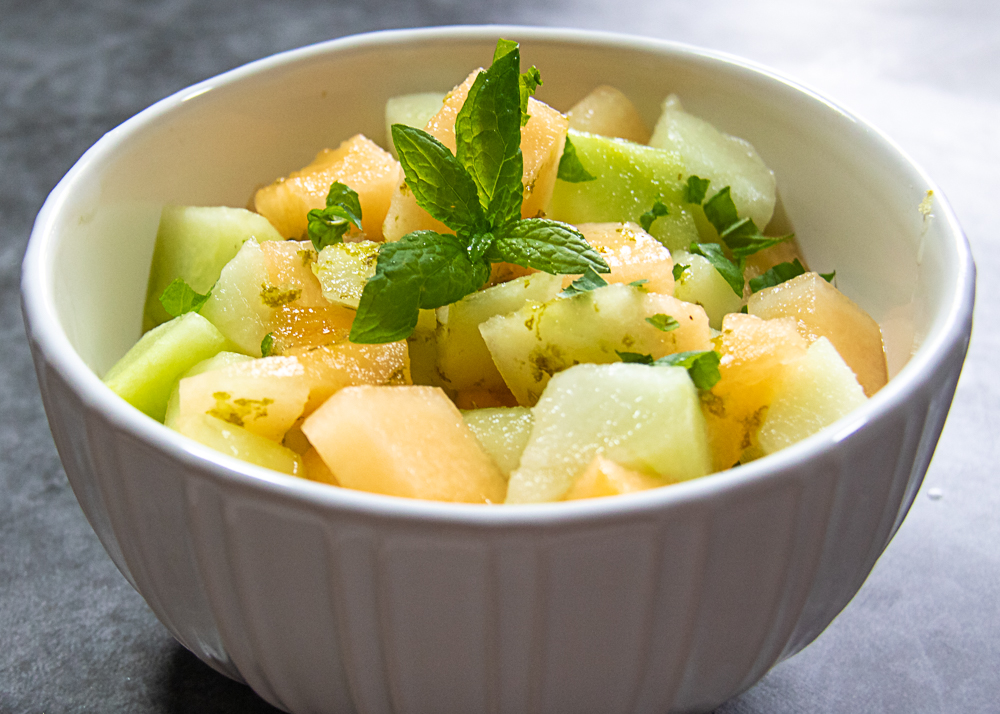 melon salad with lime dressing in white bowl