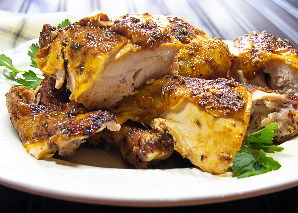 grilled rotisserie-style whole chicken cut into pieces on platter
