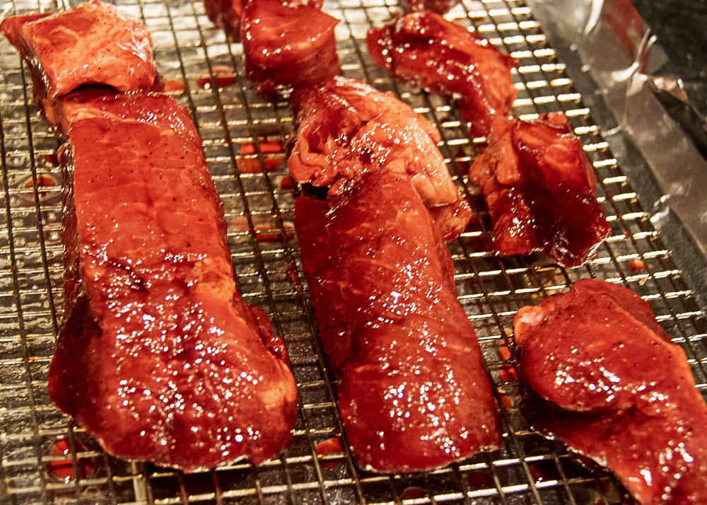 Char Siu pork arranged on wired tray nested in foil lined tray