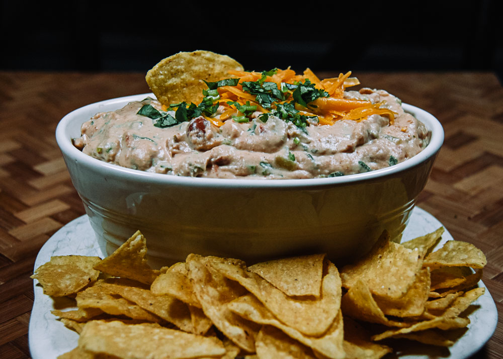 Cheesy Hot Bean Dip in a serving dish with tortilla chips