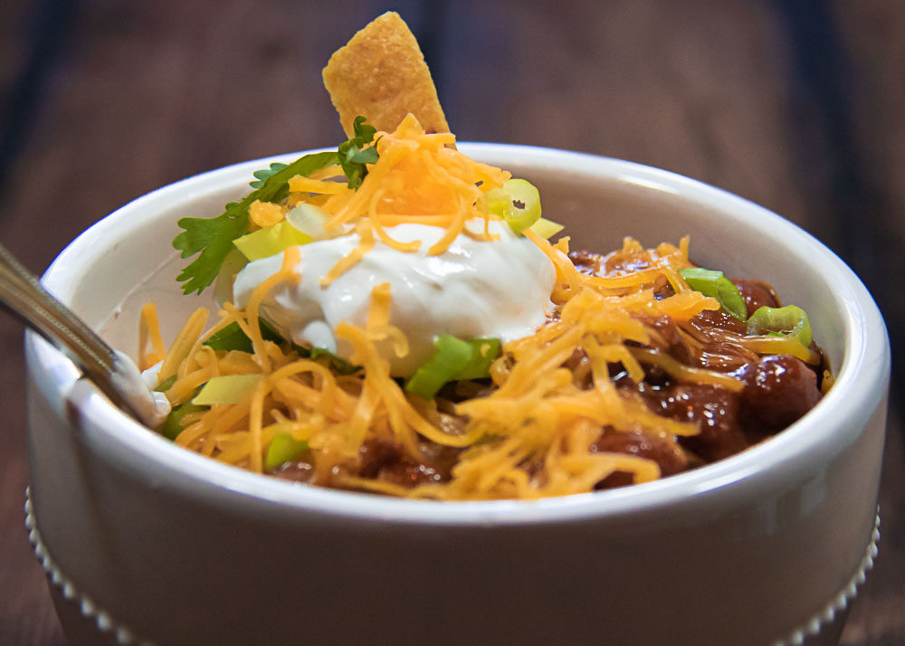 Frito Pie in a bowl with cheese and sour cream