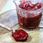 raspberry coulis in serving container and on spoon