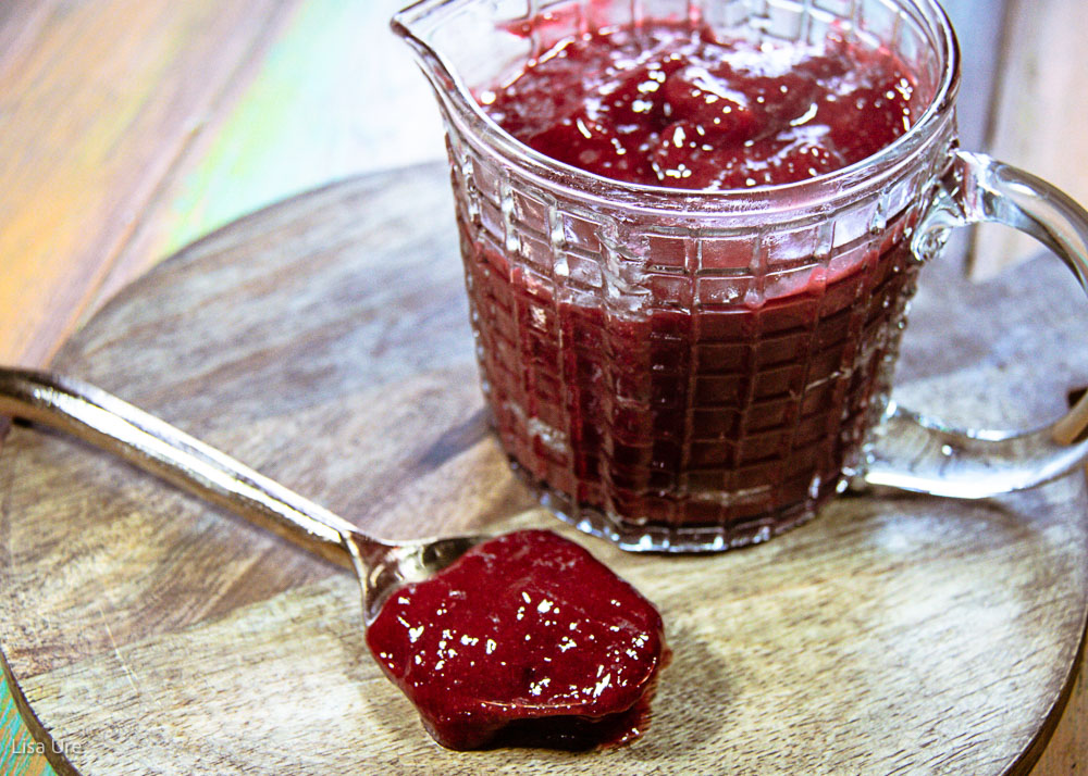 raspberry coulis in serving container and on spoon