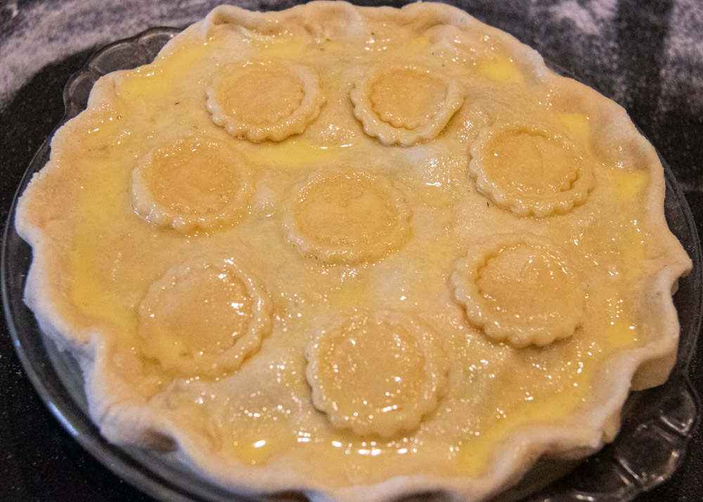 homemade chicken pot pie with decorations and egg wash all ready to be baked.